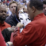 
              North Carolina State head coach Kevin Keatts, right, places a towel over injured player Terquavion Smith, bottom left, as Smith is wheeled off the court on a stretcher during the second half of an NCAA college basketball game against North Carolina, Saturday, Jan. 21, 2023, in Chapel Hill, N.C. Smith crashed to the floor after being fouled. (AP Photo/Chris Seward)
            