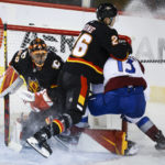 
              Colorado Avalanche forward Valeri Nichushkin, right, is checked by Calgary Flames defenceman Michael Stone, center, as they crash into Flames goalie Jacob Markstrom during the third period of an NHL hockey game Wednesday, Jan. 18, 2023, in Calgary, Alberta. (Jeff McIntosh/The Canadian Press via AP)
            