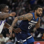 
              Minnesota Timberwolves guard D'Angelo Russell (0) works toward the basket while defended by Sacramento Kings guard Davion Mitchell, left, during the first half of an NBA basketball game, Monday, Jan. 30, 2023, in Minneapolis. (AP Photo/Abbie Parr)
            