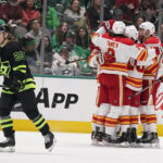 
              Dallas Stars left wing Joel Kiviranta (25) skates away as Calgary Flames center Trevor Lewis celebrates his goal with Chris Tanev (8) and other teammates during the first period of an NHL hockey game in Dallas, Saturday, Jan. 14, 2023. (AP Photo/LM Otero)
            