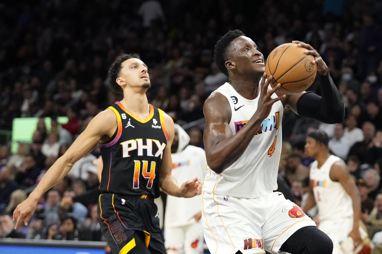 Miami Heat guard Victor Oladipo (4) drives to the basket as Phoenix Suns guard Landry Shamet (14) a...