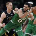 
              Boston Celtics forward Jayson Tatum (0) looks for an opening around Golden State Warriors guard Donte DiVincenzo, left, in the first half of an NBA basketball game, Thursday, Jan. 19, 2023, in Boston. (AP Photo/Steven Senne)
            