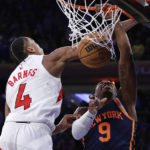 
              New York Knicks guard RJ Barrett (9) dunks in front of Toronto Raptors forward Scottie Barnes (4) at the end of the second half of an NBA basketball game Monday, Jan. 16, 2023, in New York. (AP Photo/Adam Hunger)
            
