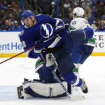 
              Tampa Bay Lightning right wing Corey Perry (10) gets knocked down by Vancouver Canucks defenseman Quinn Hughes (43) during the second period of an NHL hockey game Thursday, Jan. 12, 2023, in Tampa, Fla. (AP Photo/Chris O'Meara)
            