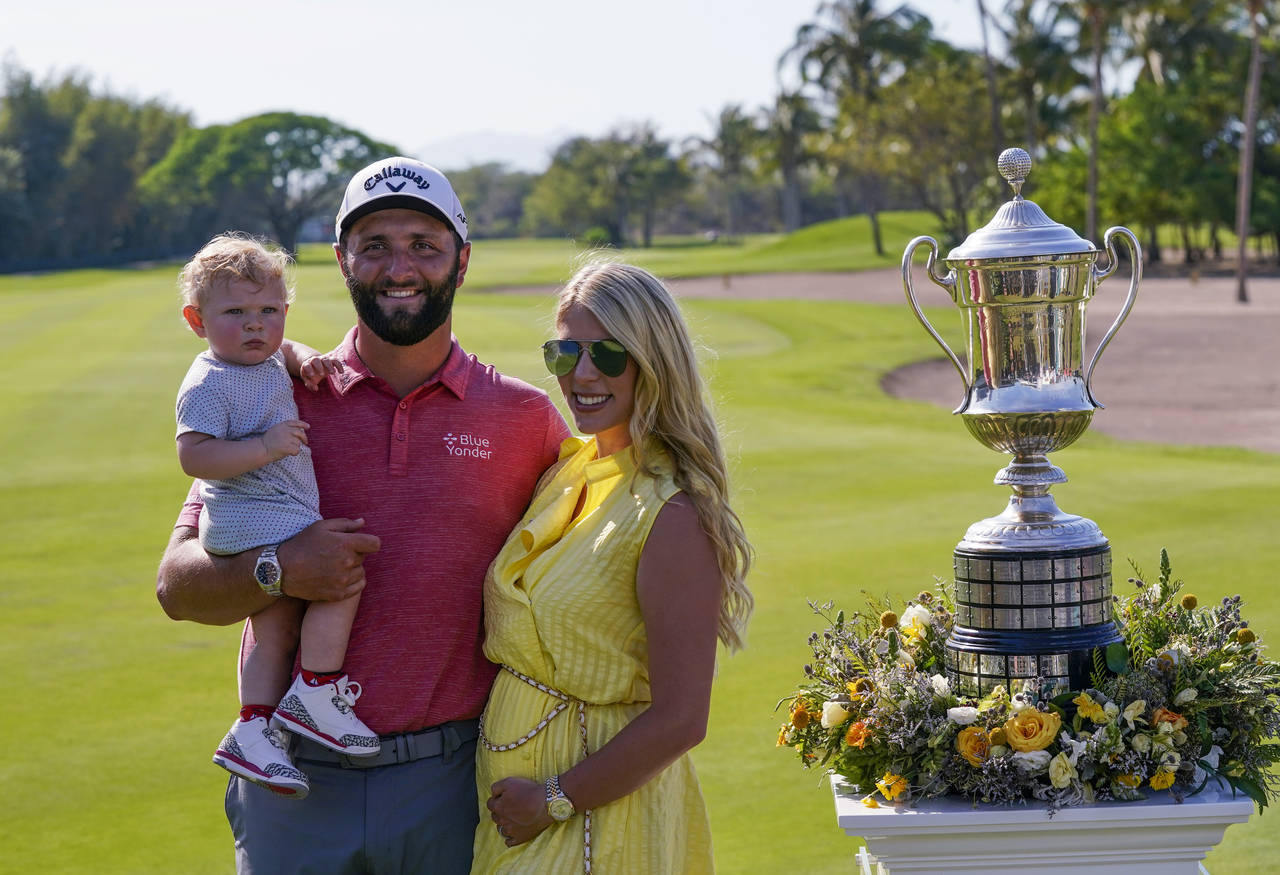 FILE - Jon Rahm, of Spain, poses for photos with his wife Kelley and his son Kepa, after winning th...