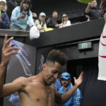 
              Michael Mmoh of the U.S. signs autographs after defeating Alexander Zverev of Germany in their second round match at the Australian Open tennis championship in Melbourne, Australia, Thursday, Jan. 19, 2023. (AP Photo/Ng Han Guan)
            