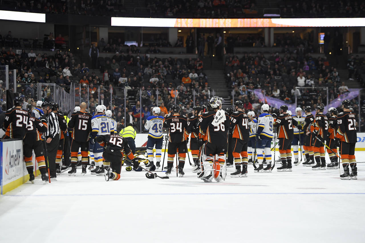 FILE -  Members of the St. Louis Blues and Anaheim Ducks gather on the ice as Blues defenseman Jay ...