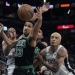 
              Boston Celtics guard Malcolm Brogdon (13) reached past San Antonio Spurs forward Jeremy Sochan, right, for a loose ball during the second half of an NBA basketball game in San Antonio, Saturday, Jan. 7, 2023. (AP Photo/Eric Gay)
            