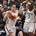 
              UConn's Lou Lopez-Senechal, center, wrestles the ball from Georgetown's Graceann Bennett, left, as UConn's Aaliyah Edwards, right, defends in the second half of an NCAA college basketball game, Sunday, Jan. 15, 2023, in Hartford, Conn. (AP Photo/Jessica Hill)
            