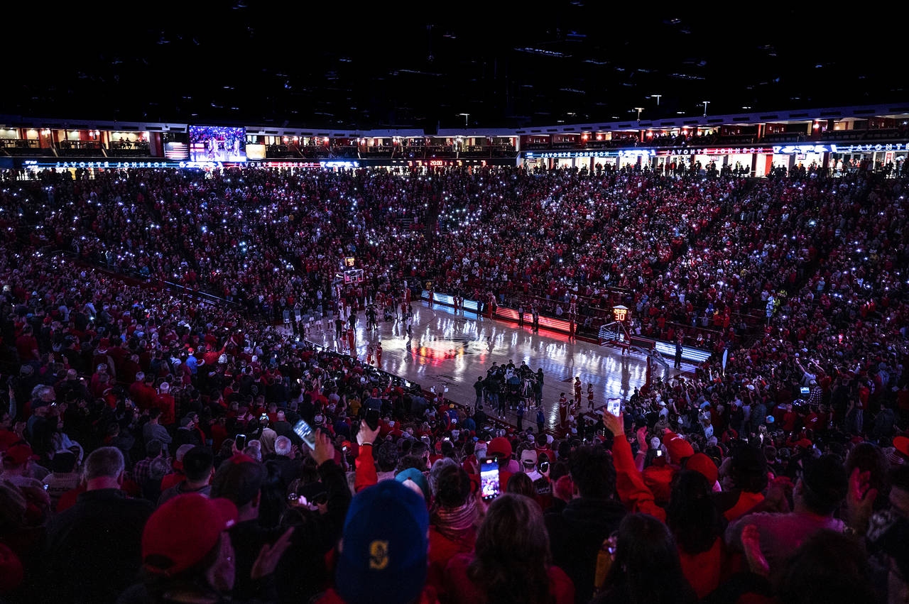 Fans light up the stands with cell phone flashlights during the first half an NCAA college basketba...