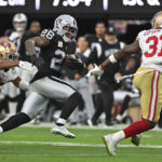 
              Las Vegas Raiders running back Josh Jacobs (28) tries to evade tackles by San Francisco 49ers cornerback Deommodore Lenoir (38) and safety Tashaun Gipson Sr. (31) during the first half of an NFL football game between the San Francisco 49ers and Las Vegas Raiders, Sunday, Jan. 1, 2023, in Las Vegas. (AP Photo/David Becker)
            
