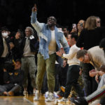 
              Former NFL player Shannon Sharpe, center, stands up during the second half an NBA basketball game between the Memphis Grizzlies and the Los Angeles Lakers in Los Angeles, Friday, Jan. 20, 2023. At halftime, Sharpe confronted Memphis Grizzlies forward Dillon Brooks and center Steven Adams. (AP Photo/Ashley Landis)
            