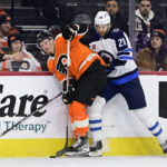 
              Philadelphia Flyers' Wade Allison, left, plays the puck against Winnipeg Jets' Kevin Stenlund during the first period of an NHL hockey game, Sunday, Jan. 22, 2023, in Philadelphia. (AP Photo/Derik Hamilton)
            