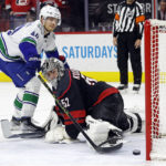 
              Vancouver Canucks' Elias Pettersson (40) slips the puck past Carolina Hurricanes goaltender Pyotr Kochetkov (52) to win the game in a shoot out at an NHL hockey game in Raleigh, N.C., Sunday, Jan. 15, 2023. (AP Photo/Karl B DeBlaker)
            