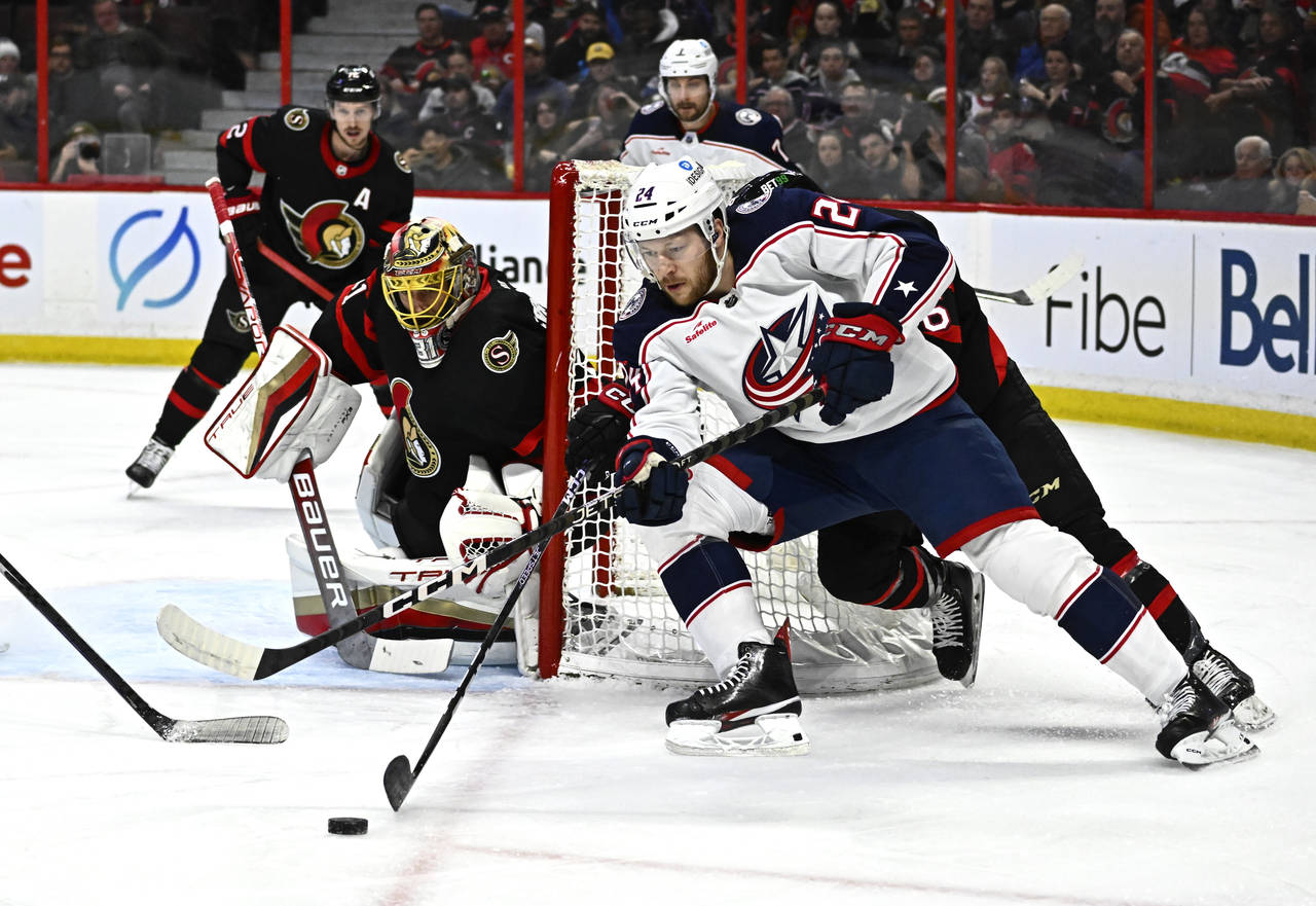 Columbus Blue Jackets right wing Mathieu Olivier (24) tries to wrap the puck around the net of Otta...