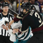 
              Arizona Coyotes defenseman Josh Brown (3) lands a punch during a fight against San Jose Sharks center Michael Eyssimont as linesman Devin Berg, left, looks on during the first period of an NHL hockey game in Tempe, Ariz., Tuesday, Jan. 10, 2023. (AP Photo/Ross D. Franklin)
            