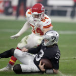 
              Las Vegas Raiders quarterback Jarrett Stidham (3) slides after running for yardage as Kansas City Chiefs linebacker Leo Chenal (54) defends during the second half of an NFL football game Saturday, Jan. 7, 2023, in Las Vegas. (AP Photo/John Locher)
            