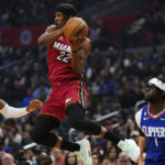 
              Miami Heat forward Jimmy Butler (22) jumps to the basket against Los Angeles Clippers forward Marcus Morris Sr. (8) and Los Angeles Clippers guard Reggie Jackson (1) during the first half of an NBA basketball game, Monday, Jan. 2, 2023, in Los Angeles. (AP Photo/Allison Dinner)
            