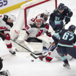 
              New Jersey Devils goaltender Mackenzie Blackwood (29) and defenseman Brendan Smith (2) battle to keep the puck out of the goal against Seattle Kraken center Morgan Geekie (67) and right wing Daniel Sprong (91) during the second period of an NHL hockey game, Thursday, Jan. 19, 2023, in Seattle. (AP Photo/John Froschauer)
            