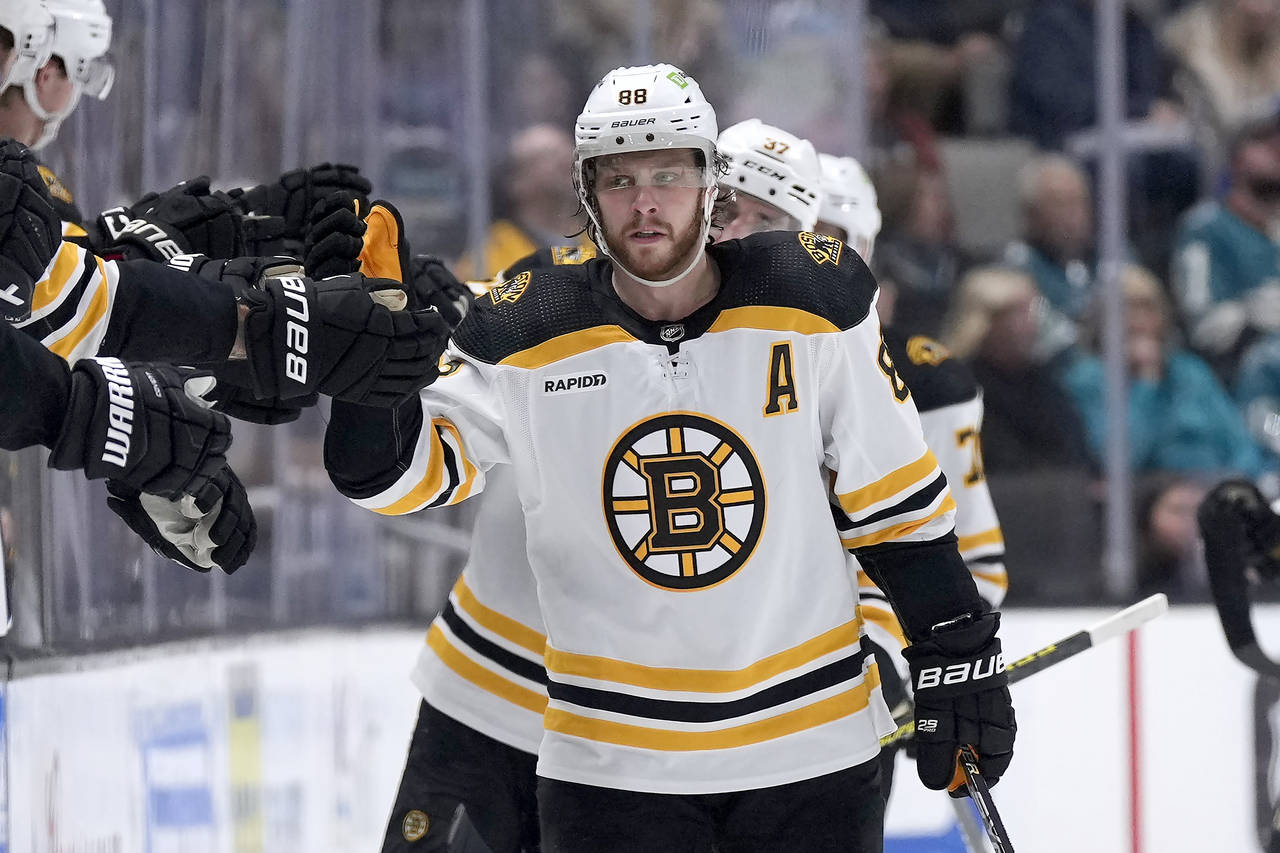 Boston Bruins' David Pastrnak (88) is congratulated by teammates on the bench after his goal agains...