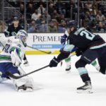 
              Seattle Kraken center Alex Wennberg (21) sends the puck past Vancouver Canucks goaltender Spencer Martin (30) for a goal during the first period of an NHL hockey game Wednesday, Jan. 25, 2023, in Seattle. (AP Photo/John Froschauer)
            