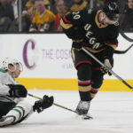 
              Dallas Stars left wing Jason Robertson (21) and Vegas Golden Knights center Chandler Stephenson (20) battle for the puck during the first period of an NHL hockey game Monday, Jan. 16, 2023, in Las Vegas. (AP Photo/John Locher)
            