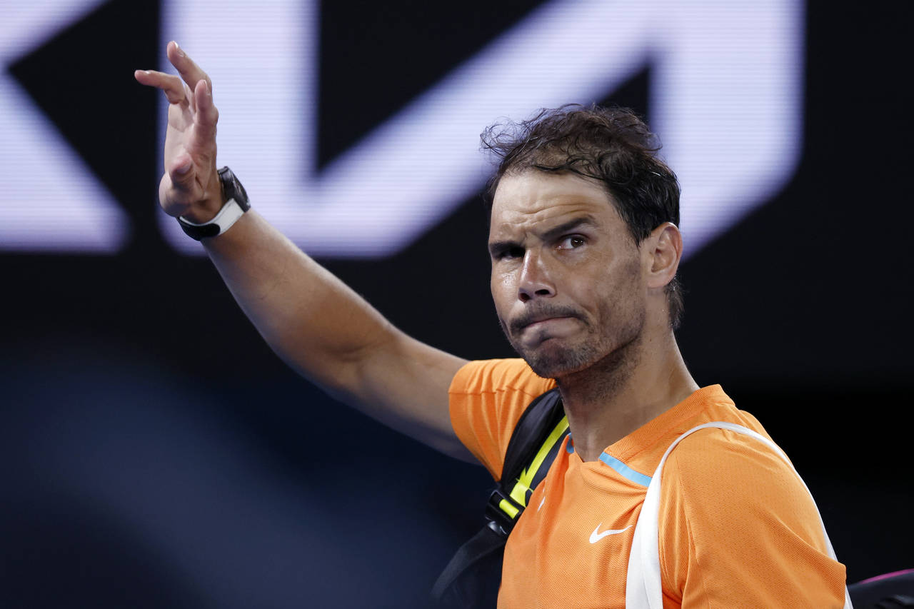 Rafael Nadal of Spain waves as he leaves Rod Laver Arena following his second round loss to Mackenz...
