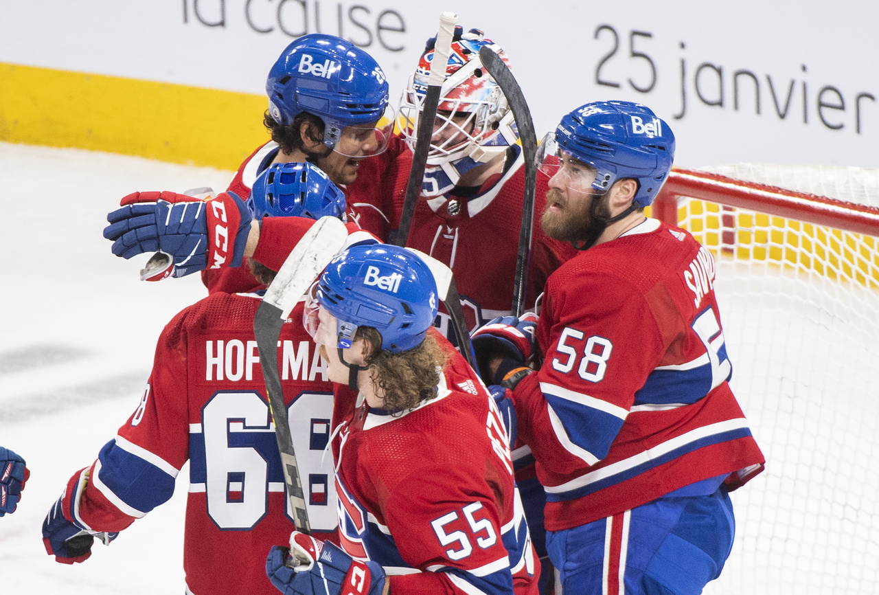 Montreal Canadiens goaltender Sam Montembeault, center, celebrates with teammates after defeating t...