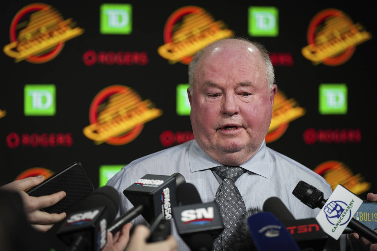 Vancouver Canucks coach Bruce Boudreau responds to questions during a news conference after the tea...
