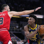 
              Indiana Pacers forward Aaron Nesmith (23) cuts under Chicago Bulls guard Zach LaVine (8) during the first half of an NBA basketball game in Indianapolis, Tuesday, Jan. 24, 2023. (AP Photo/Michael Conroy)
            