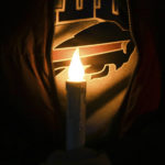 
              A person holds an electric candle during a vigil for Buffalo Bills safety Damar Hamlin on Tuesday, Jan. 3, 2023, in Orchard Park, N.Y. Hamlin collapsed Monday while going into cardiac arrest after making what appeared to be a routine tackle during the team's NFL football game against the Cincinnati Bengals. Hamlin was sedated and in critical condition Tuesday. (AP Photo/Joshua Bessex)
            