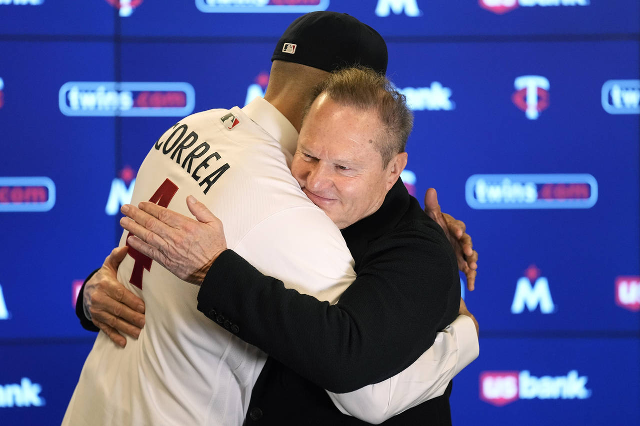 Minnesota Twins' Carlos Correa, left, and agent Scott Boras hug following a baseball press conferen...