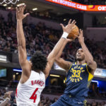 
              Indiana Pacers center Myles Turner (33) shoots while being defended by Toronto Raptors forward Scottie Barnes (4) during the second half of an NBA basketball game in Indianapolis, Monday, Jan. 2, 2023. (AP Photo/Doug McSchooler)
            
