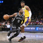 
              Brooklyn Nets guard Kyrie Irving (11) drives past Los Angeles Lakers forward Rui Hachimura (28) during the first half of an NBA basketball game Monday, Jan. 30, 2023, in New York. (AP Photo/Corey Sipkin)
            