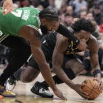 
              Toronto Raptors forward O.G. Anunoby, right, gets a hand to the face as he battles Boston Celtics guard Jaylen Brown (7) for control of the ball during first-half NBA basketball game action in Toronto, Saturday, Jan. 21, 2023. (Frank Gunn/The Canadian Press via AP)
            