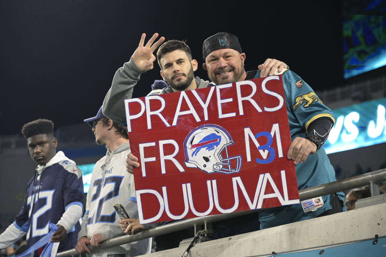 Fans display a sign honoring injured Buffalo Bills player Damar Hamlin before an NFL football game ...