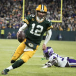 
              Green Bay Packers quarterback Aaron Rodgers (12) runs from Minnesota Vikings linebacker Brian Asamoah II, right, during a 2-yard touchdown run in the second half of an NFL football game, Sunday, Jan. 1, 2023, in Green Bay, Wis. (AP Photo/Morry Gash)
            
