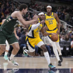 
              Indiana Pacers' Buddy Hield (24) goes to the basket against Milwaukee Bucks' Brook Lopez (11) during the first half of an NBA basketball game, Friday, Jan. 27, 2023, in Indianapolis. (AP Photo/Darron Cummings)
            