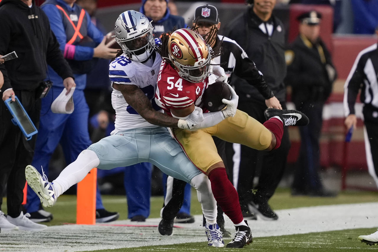 San Francisco 49ers linebacker Fred Warner (54) is tackled by Dallas Cowboys wide receiver CeeDee L...