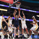 
              Washington Wizards forward Deni Avdija (9) goes up for a rebound against Golden State Warriors forward Anthony Lamb (40) and guard Ty Jerome (10) during the first half of an NBA basketball game, Monday, Jan. 16, 2023, in Washington. (AP Photo/Jess Rapfogel)
            
