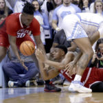 
              North Carolina State guard Casey Morsell, bottom, passes the ball to forward D.J. Burns Jr. (30) after he got control of the ball against North Carolina forward Armando Bacot, right, during the second half of an NCAA college basketball game Saturday, Jan. 21, 2023, in Chapel Hill, N.C. (AP Photo/Chris Seward)
            