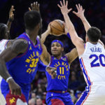 
              Denver Nuggets' Bruce Brown (11) looks to pass the ball against the defense of Philadelphia 76ers' Shake Milton (18) and Georges Niang (20) during the first half of an NBA basketball game, Saturday, Jan. 28, 2023, in Philadelphia. (AP Photo/Derik Hamilton)
            