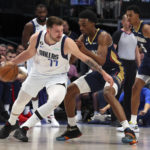 
              Dallas Mavericks guard Luka Doncic (77) is defended by New Orleans Pelicans forward Herbert Jones (5) in the first half during an NBA basketball game on Saturday, Jan. 7, 2023, in Dallas. (AP Photo/Richard W. Rodriguez)
            