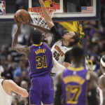 
              Denver Nuggets forward Aaron Gordon, center right, goes up to block a shot by Los Angeles Lakers center Thomas Bryant (31) in the first half of an NBA basketball game Monday, Jan. 9, 2023, in Denver. (AP Photo/David Zalubowski)
            
