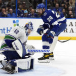 
              Vancouver Canucks goaltender Collin Delia (60) makes a save on a deflection by Tampa Bay Lightning left wing Nicholas Paul (20) during the second period of an NHL hockey game Thursday, Jan. 12, 2023, in Tampa, Fla. (AP Photo/Chris O'Meara)
            