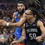 
              Oklahoma City Thunder's Kenrich Williams, left, grabs a pass behind Orlando Magic's Cole Anthony (50) during the first half of an NBA basketball game Wednesday, Jan. 4, 2023, in Orlando, Fla. (AP Photo/John Raoux)
            