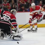 
              Calgary Flames center Trevor Lewis' (22) is deflected by Chicago Blackhawks goaltender Alex Stalock (32) during the second period of an NHL hockey game, Sunday, Jan. 8, 2023, in Chicago. (AP Photo/Erin Hooley)
            