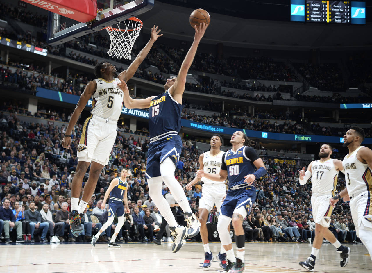 Denver Nuggets center Nikola Jokic, right, goes up for a basket as New Orleans Pelicans forward Her...