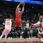 
              Chicago Bulls guard Alex Caruso (6) goes to the basket against Washington Wizards guard Delon Wright (55) and forward Rui Hachimura, right, during the first half of an NBA basketball game, Wednesday, Jan. 11, 2023, in Washington. (AP Photo/Nick Wass)
            