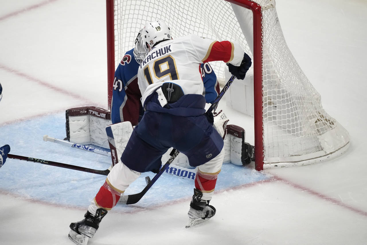 Florida Panthers left wing Matthew Tkachuk, front, shoots against  Colorado Avalanche goaltender Al...